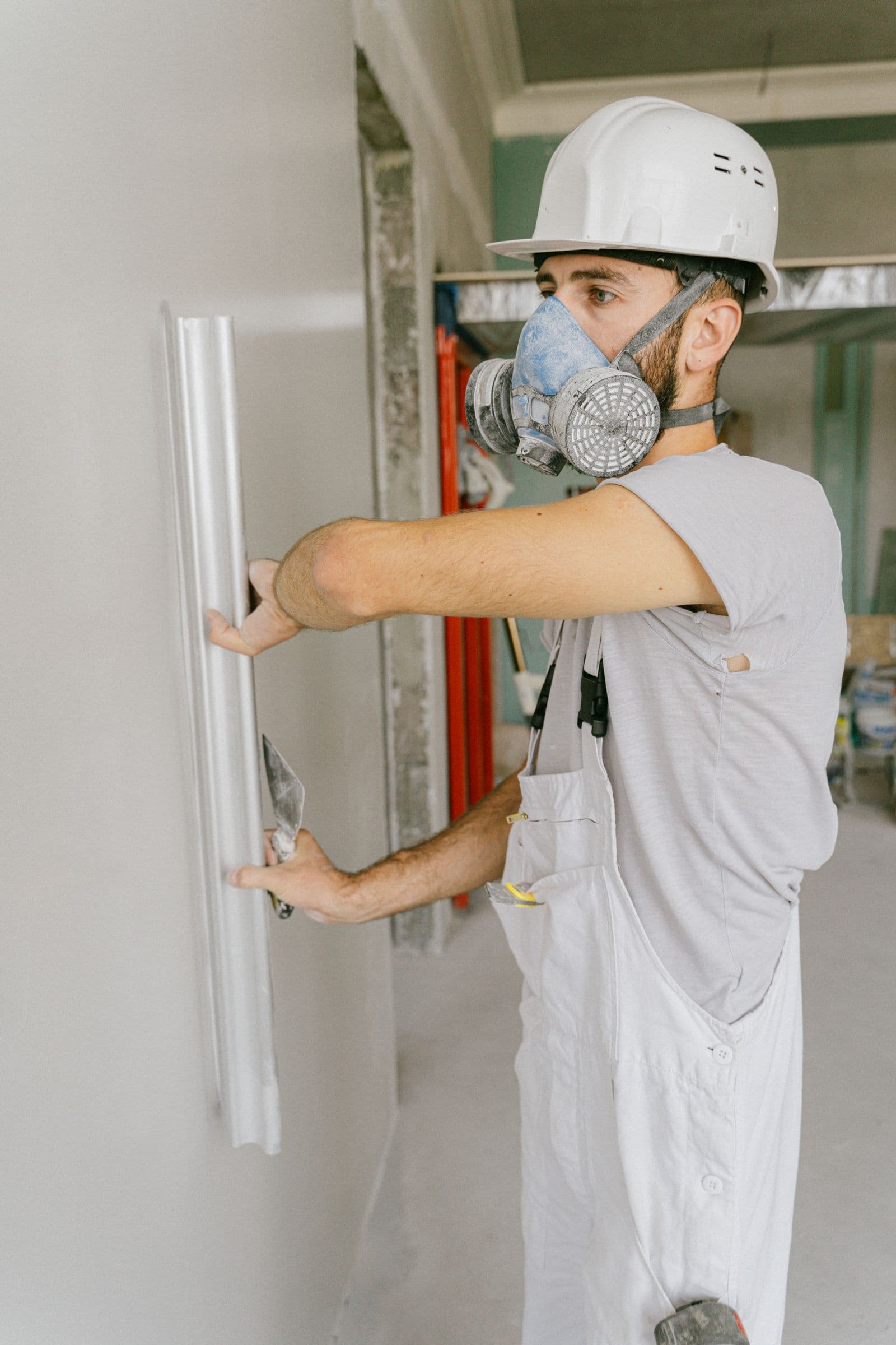 LevelWall drywall technician using a level and trowel to finish a taped seam on a job site in Waco, TX
